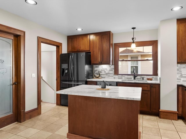 kitchen featuring a sink, pendant lighting, light tile patterned floors, and freestanding refrigerator