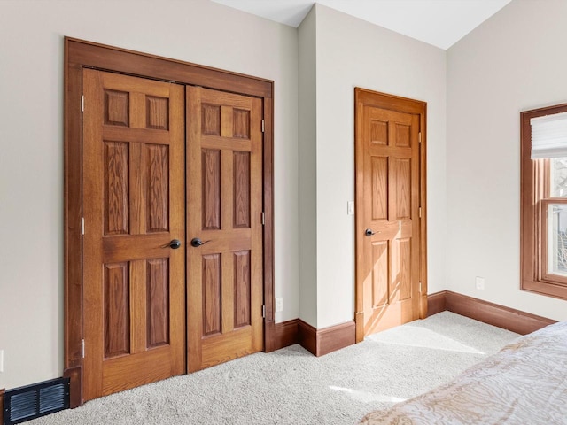 bedroom featuring visible vents, baseboards, carpet, and a closet