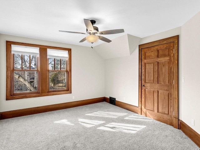 interior space with carpet flooring, baseboards, lofted ceiling, and a ceiling fan