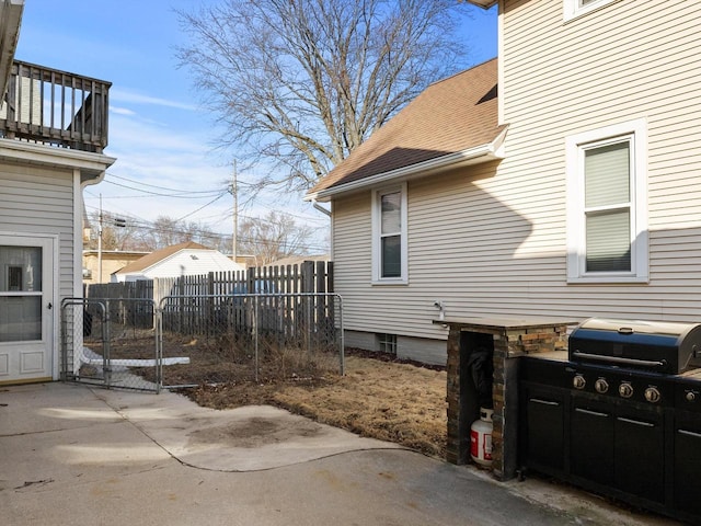 exterior space with a shingled roof and fence