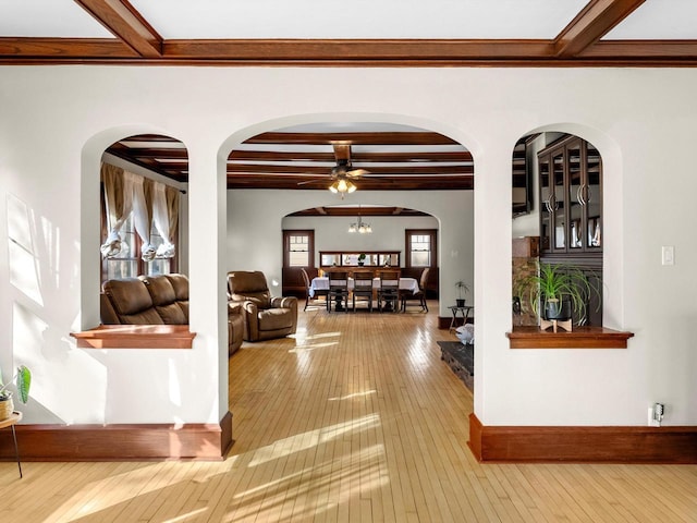 living area featuring hardwood / wood-style floors, beam ceiling, and baseboards