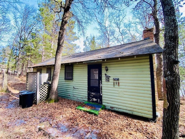 view of front of property featuring faux log siding and a chimney