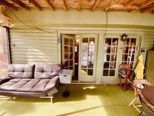 living area with wooden ceiling, beamed ceiling, and carpet flooring