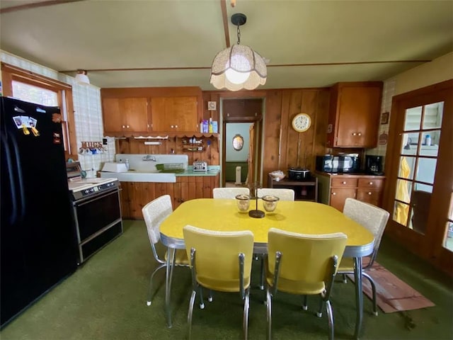 kitchen with decorative light fixtures, brown cabinets, black appliances, and light countertops