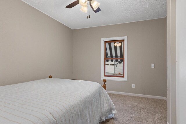 bedroom with carpet flooring, a textured ceiling, baseboards, and a ceiling fan