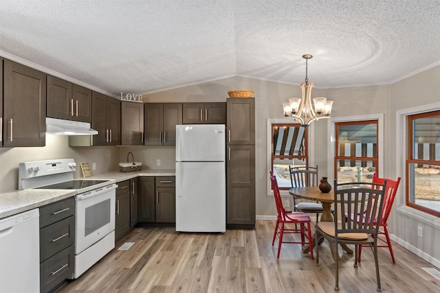 kitchen featuring under cabinet range hood, dark brown cabinetry, light countertops, vaulted ceiling, and white appliances