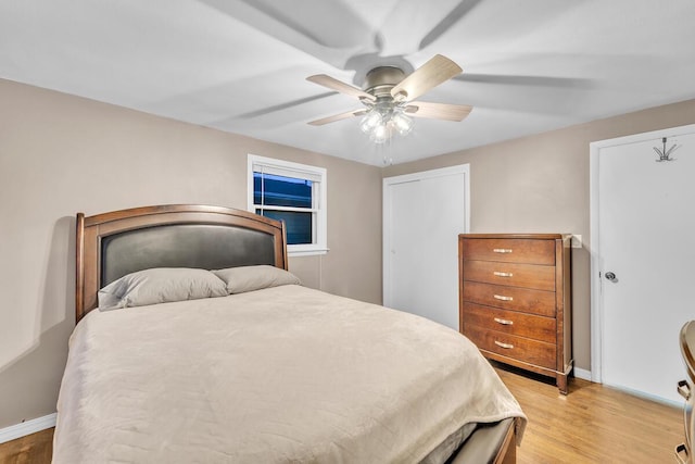 bedroom with baseboards, light wood-style floors, and ceiling fan