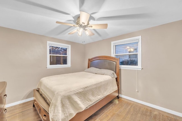 bedroom with ceiling fan, baseboards, and wood finished floors