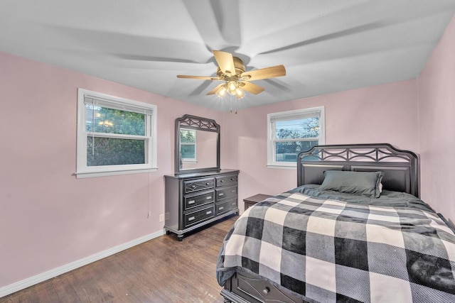 bedroom featuring ceiling fan, dark wood-type flooring, and baseboards