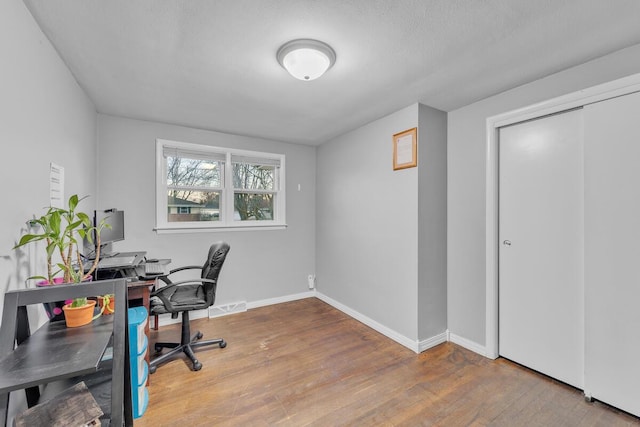 home office with visible vents, baseboards, and wood finished floors