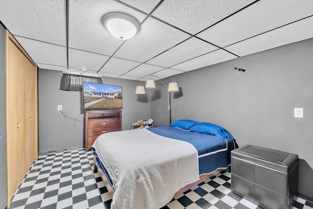 bedroom featuring tile patterned floors and a paneled ceiling