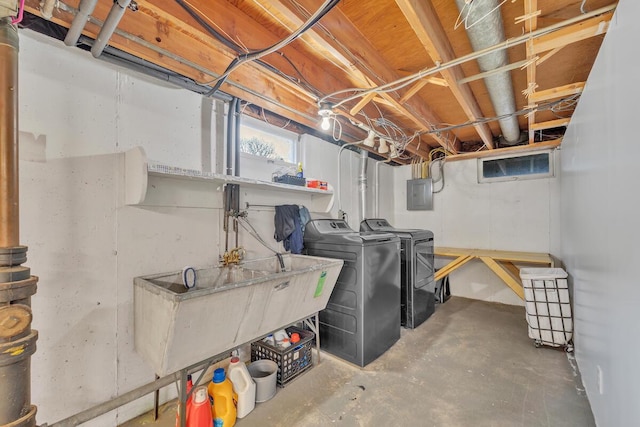 basement featuring electric panel, a sink, and separate washer and dryer