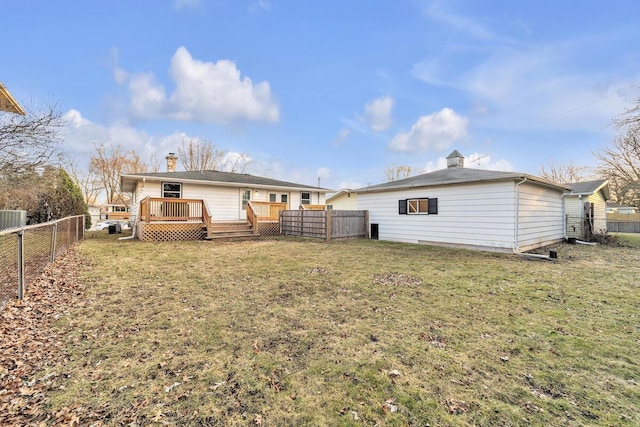 rear view of house with a wooden deck, a lawn, a fenced backyard, and a chimney