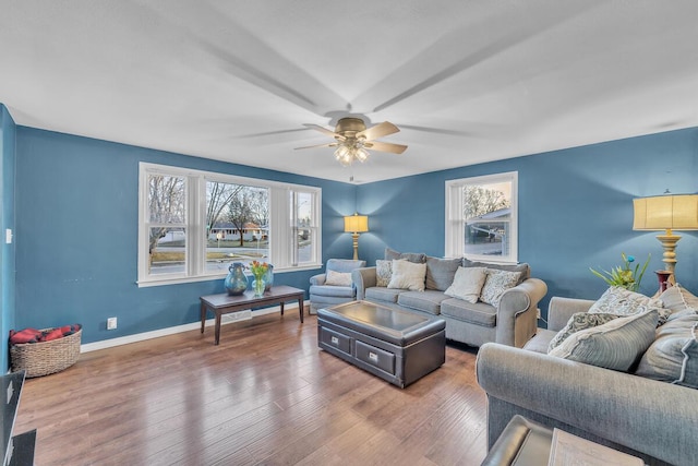 living room featuring wood finished floors, baseboards, and ceiling fan