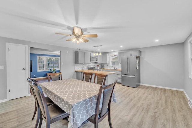 dining space featuring light wood-style flooring, recessed lighting, baseboards, and ceiling fan