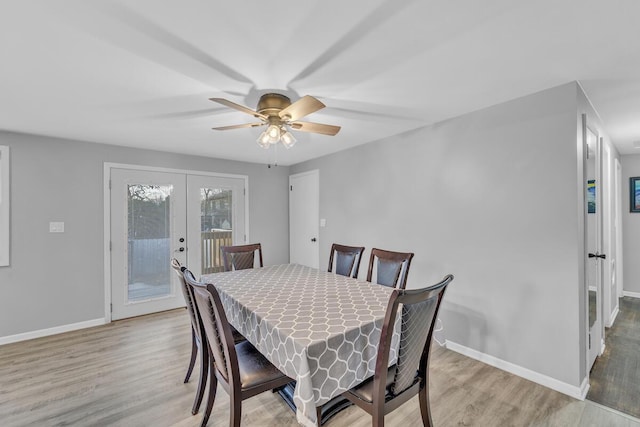 dining area with french doors, a ceiling fan, baseboards, and wood finished floors