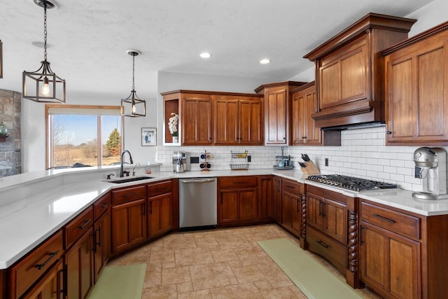 kitchen with a sink, stainless steel appliances, decorative backsplash, and light countertops