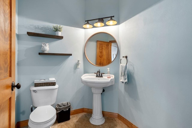 bathroom with baseboards, toilet, and tile patterned flooring