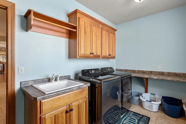 clothes washing area with separate washer and dryer, cabinet space, and a sink