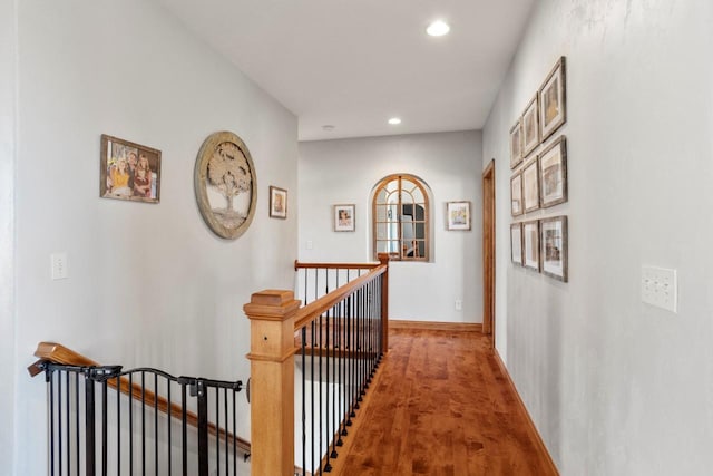 corridor featuring an upstairs landing, recessed lighting, baseboards, and wood finished floors