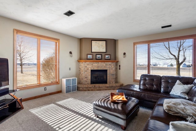 carpeted living area featuring visible vents, a brick fireplace, and baseboards