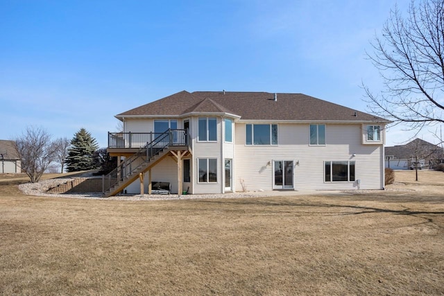 rear view of property featuring stairway, a lawn, and a wooden deck