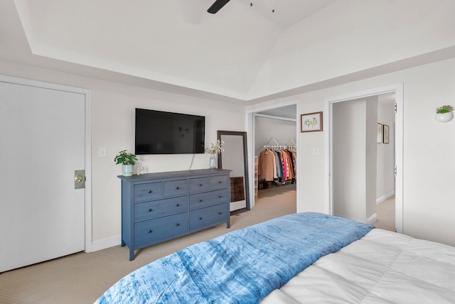 bedroom with a ceiling fan, a closet, light colored carpet, a spacious closet, and vaulted ceiling