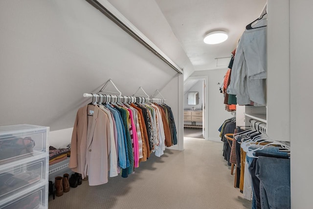 walk in closet featuring carpet and vaulted ceiling