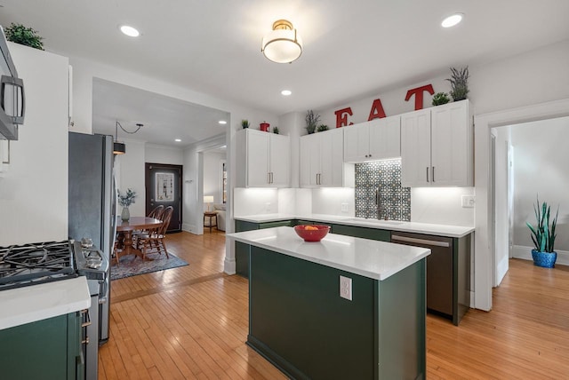 kitchen featuring a sink, appliances with stainless steel finishes, green cabinets, and light countertops