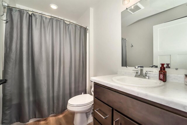 bathroom with vanity, a shower with shower curtain, wood finished floors, visible vents, and toilet