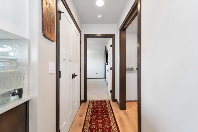 hallway featuring light wood-type flooring and washer / dryer