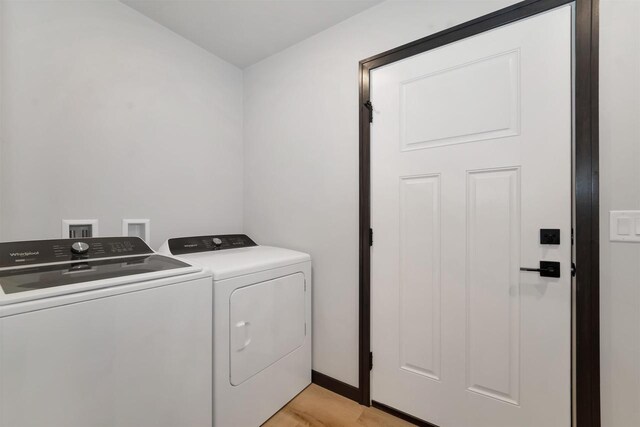 clothes washing area featuring light wood-style floors, laundry area, and washer and clothes dryer