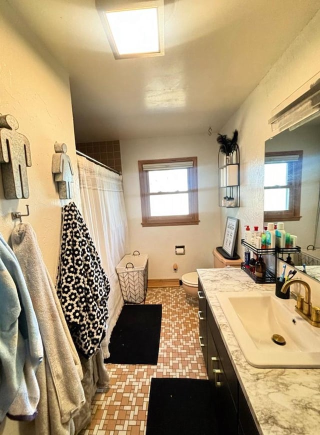 full bathroom featuring vanity, toilet, a shower with curtain, and baseboards