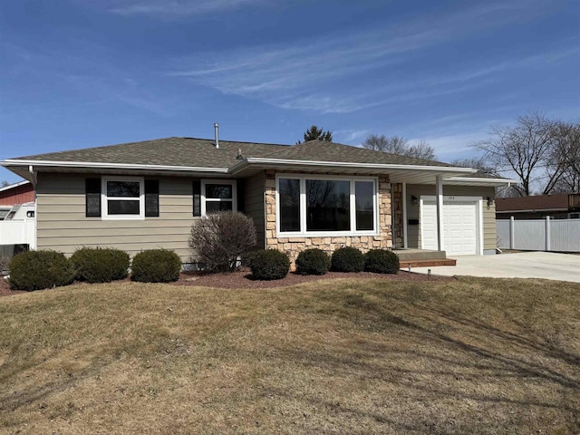 ranch-style house featuring a front lawn, driveway, stone siding, fence, and a garage