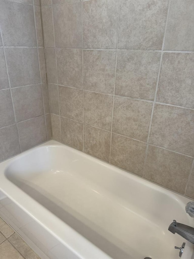 bathroom with tile patterned floors and a bathtub