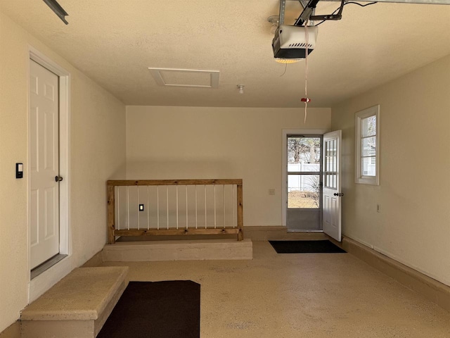 garage featuring a garage door opener and baseboards