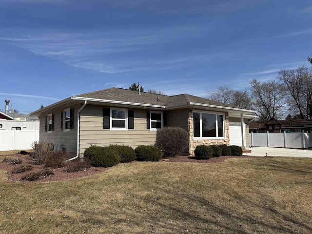 view of front of home with a front lawn, concrete driveway, and fence