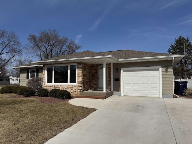 ranch-style home featuring concrete driveway, a front yard, roof with shingles, a garage, and stone siding