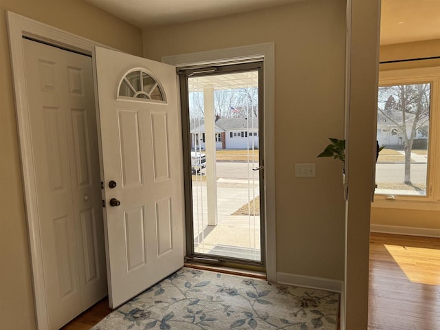 foyer with baseboards and wood finished floors