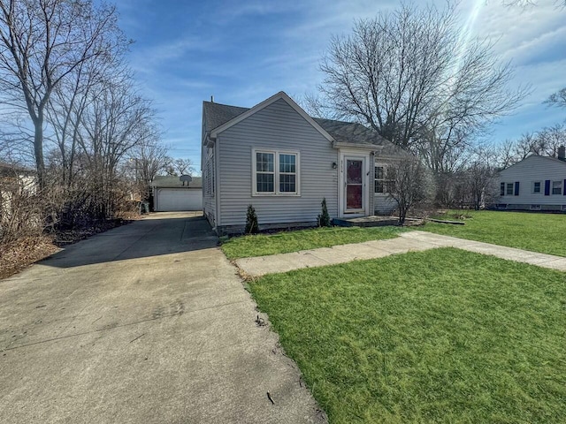 view of front facade with an outbuilding, a front yard, and a detached garage