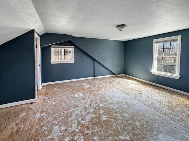 bonus room featuring a wealth of natural light, baseboards, and lofted ceiling