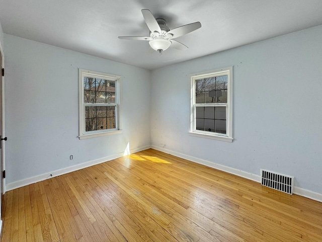 empty room featuring visible vents, a healthy amount of sunlight, and light wood-type flooring