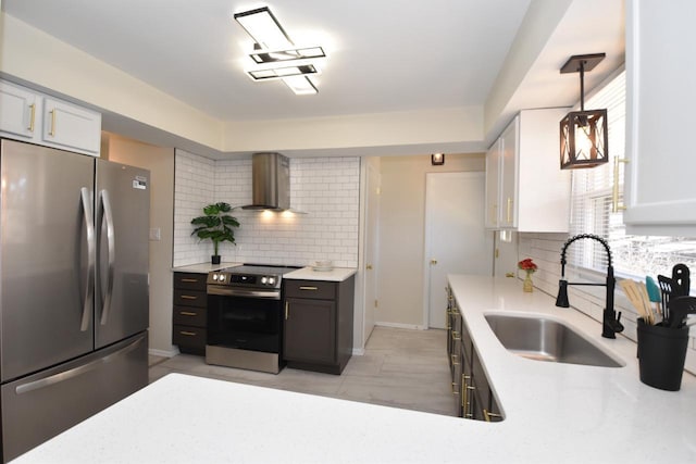 kitchen featuring a sink, stainless steel appliances, tasteful backsplash, and wall chimney range hood