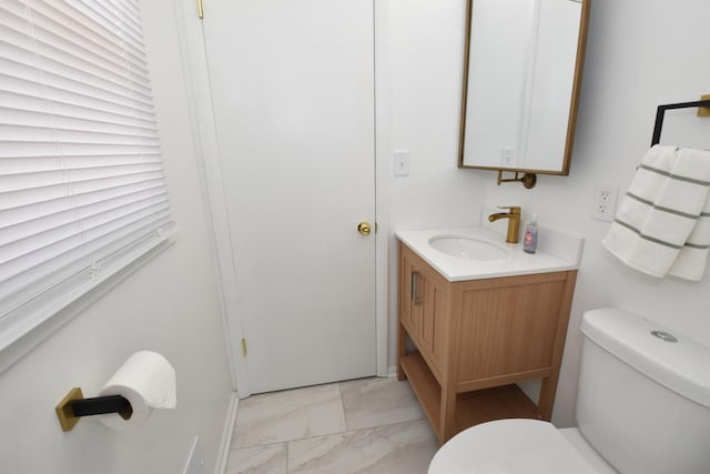 bathroom with vanity, toilet, and marble finish floor