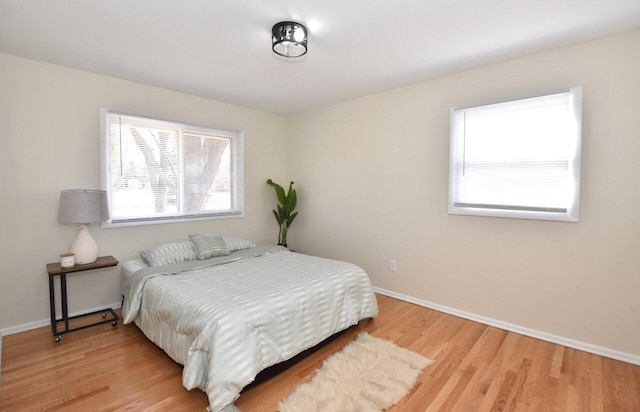 bedroom with light wood-type flooring and baseboards