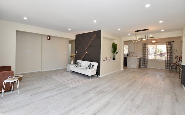 unfurnished living room featuring recessed lighting, light wood-type flooring, and baseboards