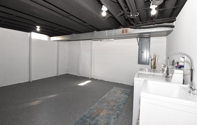 finished below grade area with electric panel, visible vents, concrete block wall, and washing machine and clothes dryer