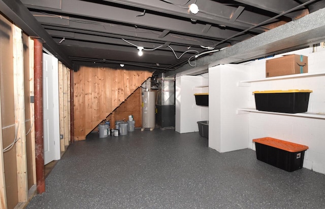 unfinished below grade area featuring concrete block wall, wood walls, and electric water heater