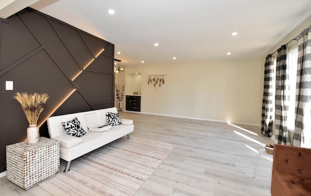 living area with recessed lighting, light wood-type flooring, and baseboards