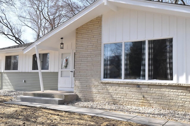 entrance to property with board and batten siding and brick siding